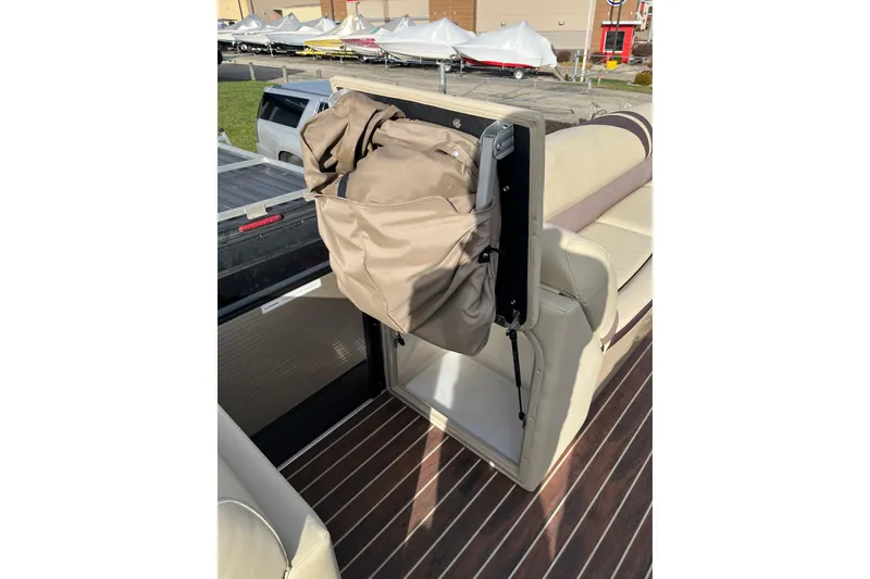 Slide: The Image of 2018 Crest Classic 250 SLS boat interior with beige seating and storage compartment. - 14