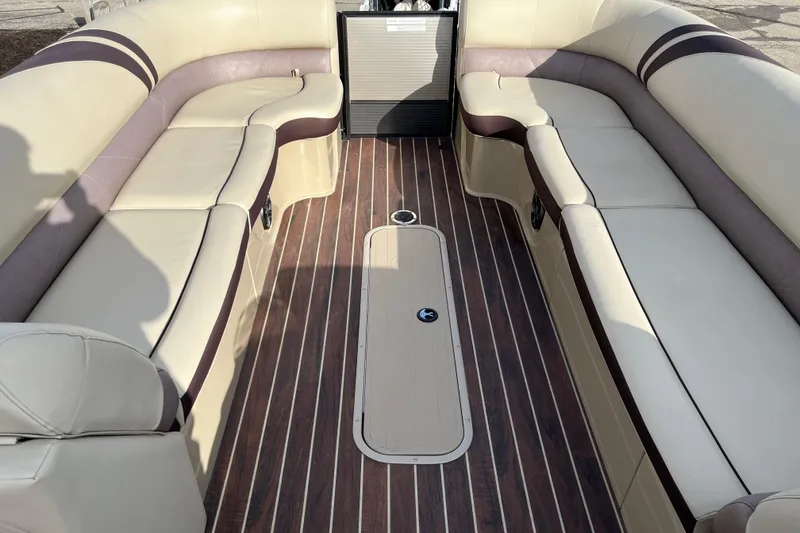 Slide: The Image of 2018 Crest Classic 250 SLS boat interior with beige seating and wood-style flooring. - 17