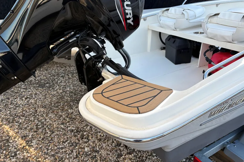 Slide: The Image of 2023 Boston Whaler 130 Super Sport boat with Mercury engine and white seating. - 3