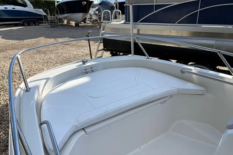 Slide: The Image of 2023 Boston Whaler 130 Super Sport boat interior with white seating and metal railings. - 5