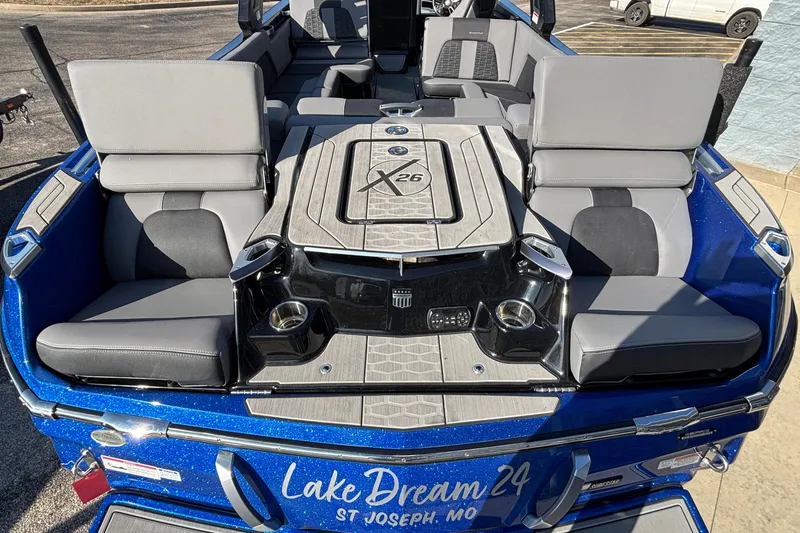 Slide: The Image of 2022 MasterCraft X26 boat interior with gray seating and blue exterior, labeled "Lake Dream 24." - 10