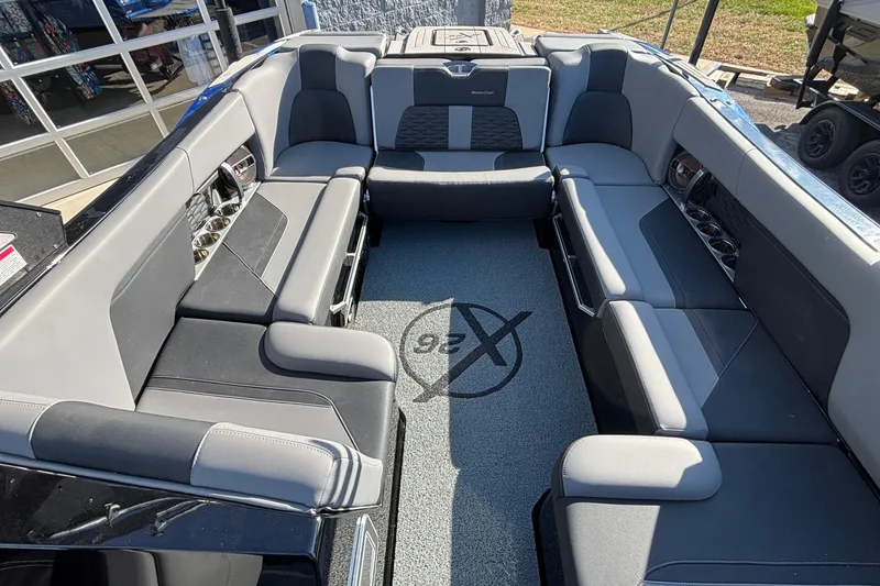 Slide: The Image of 2022 MasterCraft X26 boat interior with spacious gray seating and modern design. - 17