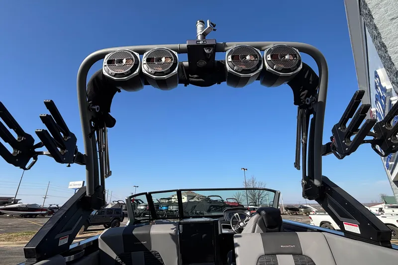 Slide: The Image of 2022 MasterCraft X26 boat with wakeboard tower and speakers under clear blue sky. - 27