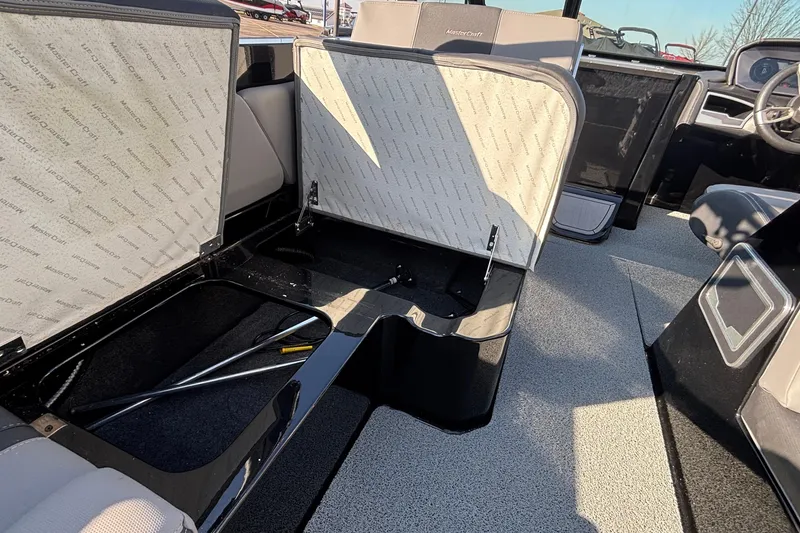 Slide: The Image of 2022 MasterCraft X26 boat interior with open storage compartments and seating. - 34
