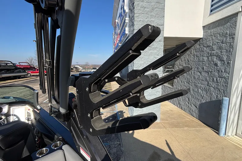 Slide: The Image of 2022 MasterCraft X26 boat with a black wakeboard rack, parked outdoors. - 40