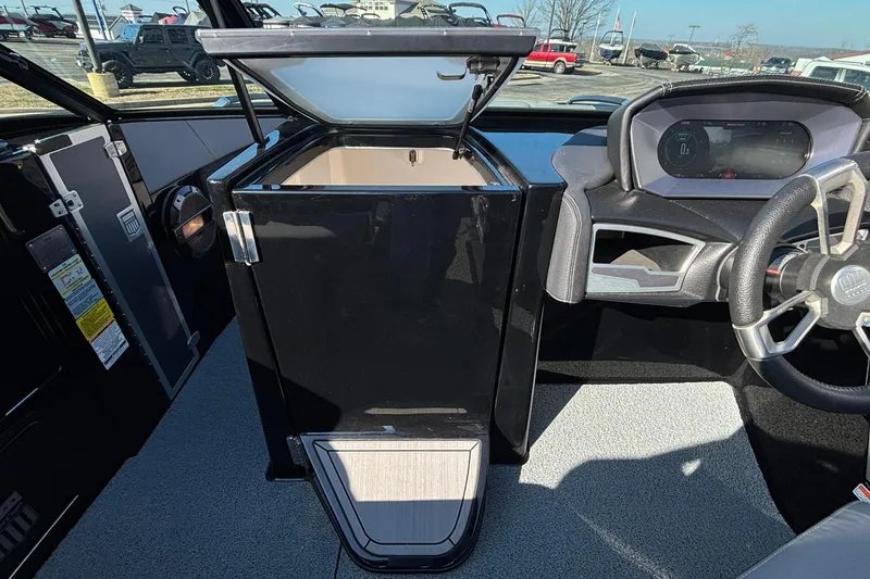 Slide: The Image of 2022 MasterCraft X26 boat interior with open storage compartment and modern dashboard. - 44