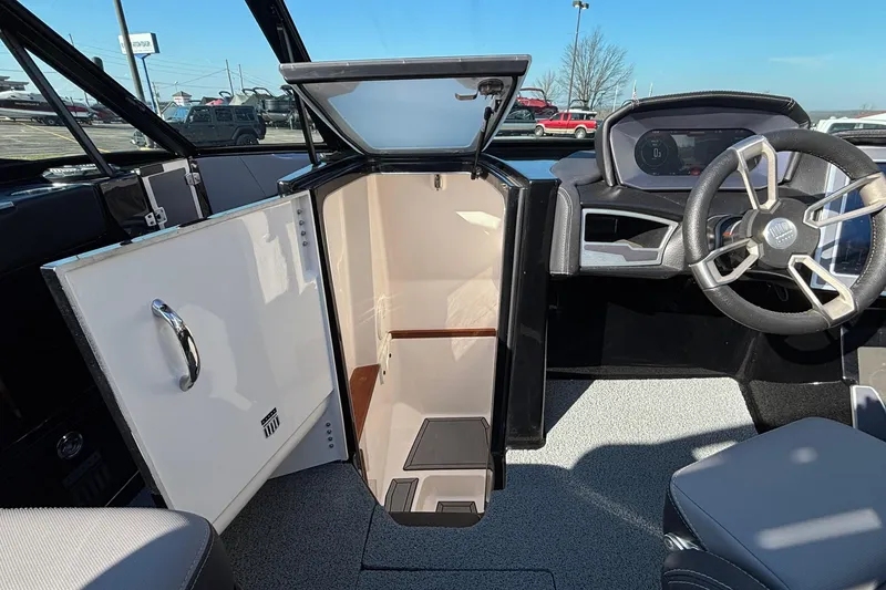 Slide: The Image of 2022 MasterCraft X26 boat interior with open cabin door and modern steering console. - 45