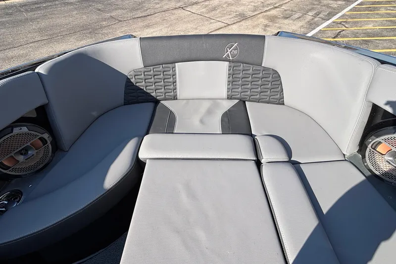 Slide: The Image of 2022 MasterCraft X26 boat interior with gray seating and speaker system. - 58