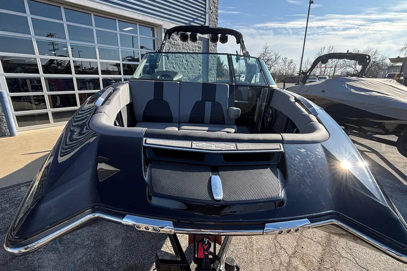 Slide: The Image of 2022 MasterCraft X26 boat with sleek design, parked outdoors under clear sky. - 61