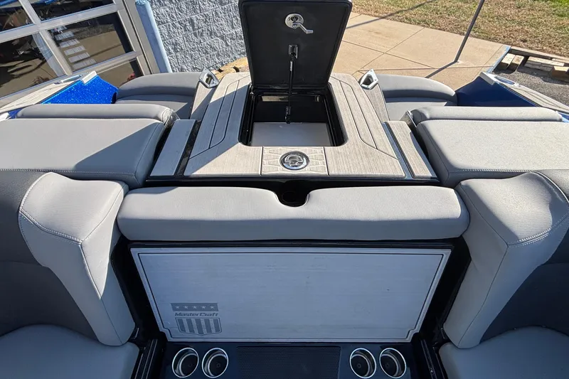 Slide: The Image of 2022 MasterCraft X26 boat interior with open storage compartment and cushioned seating. - 71