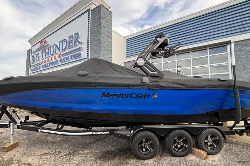 Slide: The Image of 2022 MasterCraft X26 boat in blue, covered, at Big Thunder Marine center. - 80