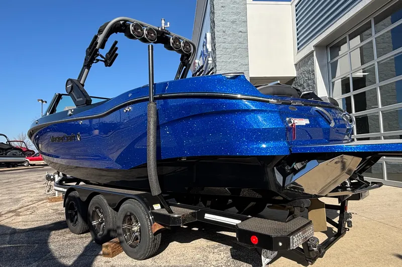 Slide: The Image of 2022 MasterCraft X26 boat in vibrant blue on a trailer outside a showroom. - 84