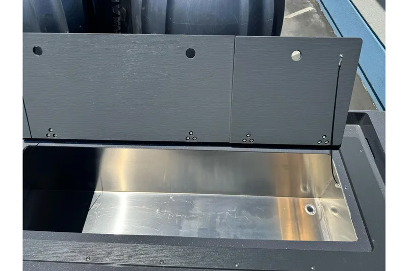 Slide: The Image of Open storage compartment on a 2026 Duckworth 28 Offshore boat, featuring a sleek metal interior. - 21