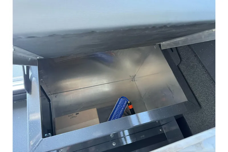 Slide: The Image of Storage compartment inside a 2026 Duckworth 28 Offshore boat, featuring a coiled hose and cardboard box. - 50