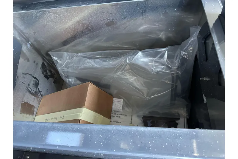 Slide: The Image of Storage compartment with plastic-wrapped items and a box in a 2026 Duckworth 28 Offshore boat. - 51