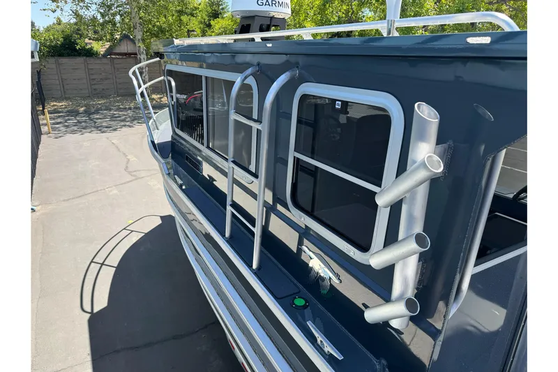 Slide: The Image of 2026 Duckworth 28 Offshore boat with rod holders and sleek design, parked outdoors. - 54