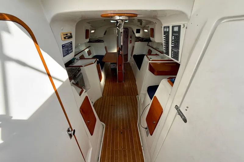 Slide: The Image of Interior of a 1985 MacGregor 65 sailboat, featuring wood accents and control panels. - 16