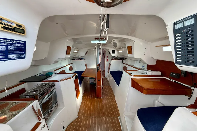 Slide: The Image of Interior of a 1985 MacGregor 65 sailboat, featuring a spacious cabin with wood accents. - 17