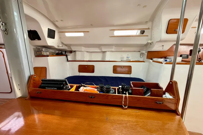 Slide: The Image of Interior of a 1985 MacGregor 65 sailboat with navigation equipment and cozy sleeping area. - 25