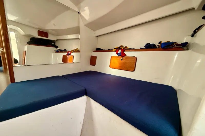 Slide: The Image of Interior cabin of 1985 MacGregor 65 sailboat with blue cushions and wooden accents. - 29