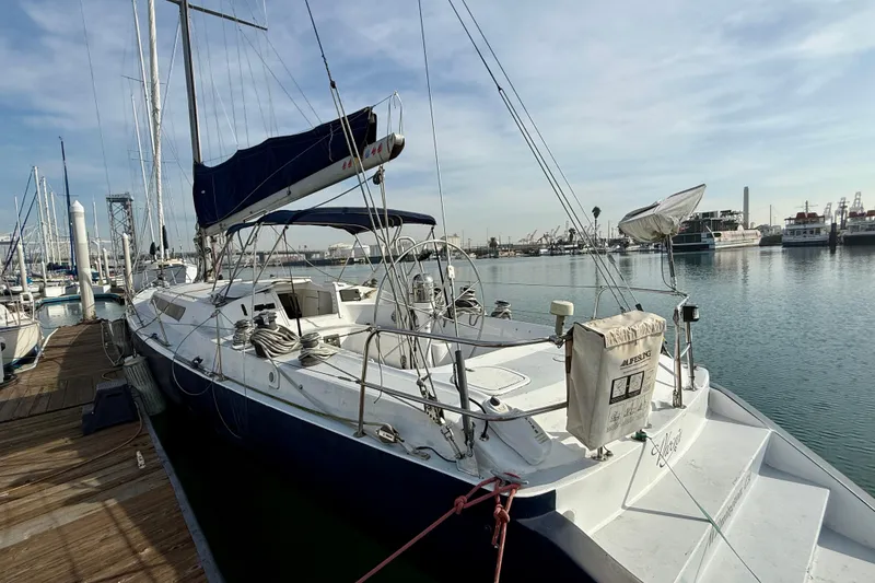 Slide: The Image of 1985 MacGregor 65 sailboat docked at marina, clear sky, calm water. - 3