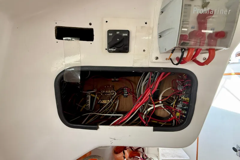 Slide: The Image of Electrical panel of a 1985 MacGregor 65 sailboat, featuring wiring and switches. - 32