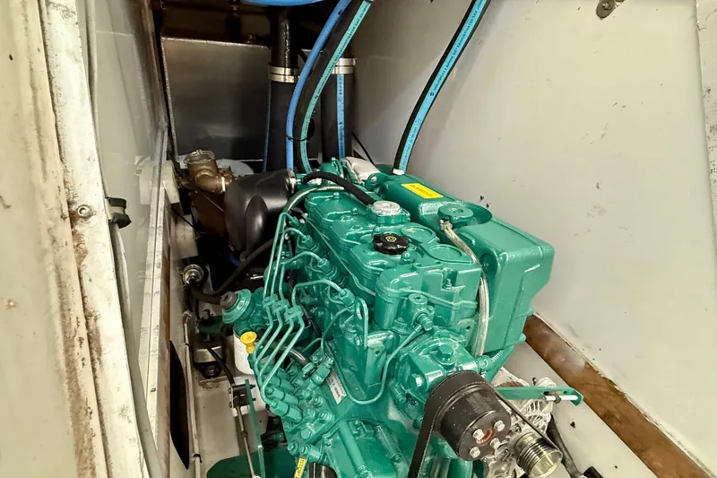 Slide: The Image of Engine compartment of a 1985 MacGregor 65 sailboat, featuring a green marine engine. - 35