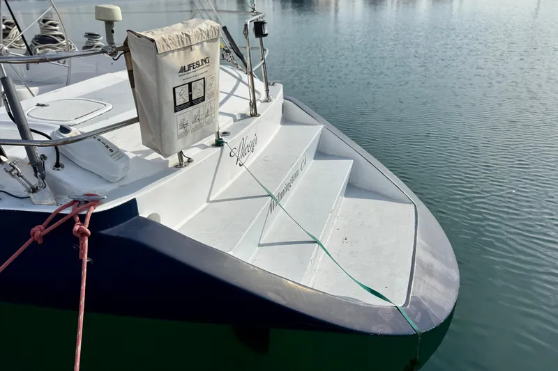 Slide: The Image of 1985 MacGregor 65 sailboat stern with lifebuoy, docked on calm water. - 4