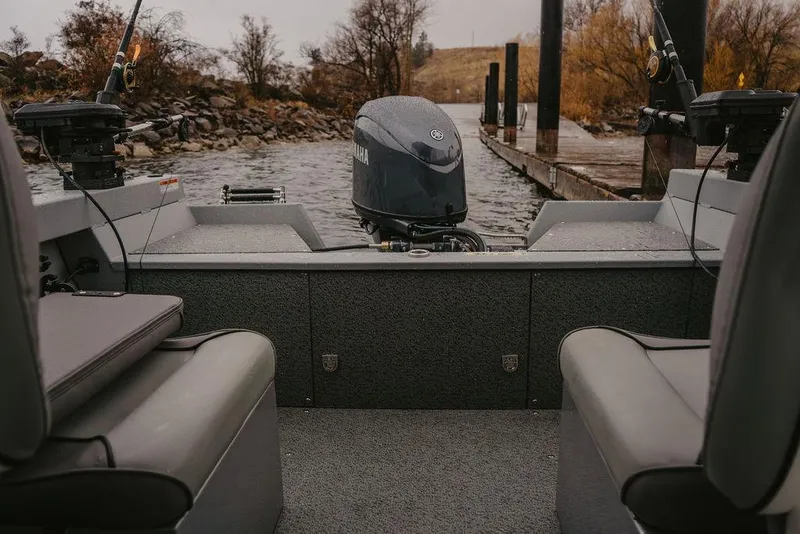 Slide: The Image of 2026 KingFisher 1625 Falcon boat interior with Yamaha motor, docked on a calm river. - 5