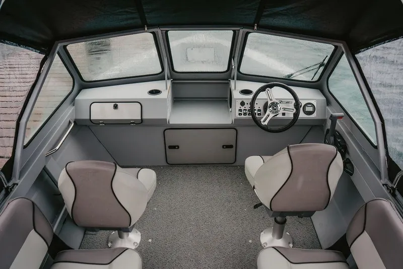 Slide: The Image of Interior of 2026 KingFisher 1625 Falcon boat with steering wheel and seating. - 7