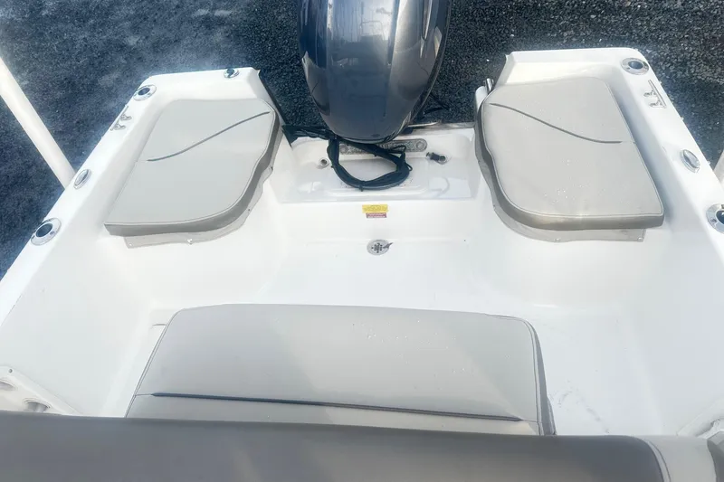 Slide: The Image of 2022 Key West 1720 Center Console boat interior with cushioned seating and motor. - 11