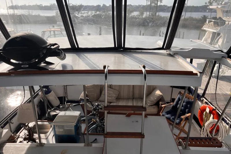 Slide: The Image of 1986 Jefferson 42 SE Sundeck Motor Yacht interior with seating and outdoor grill. - 13