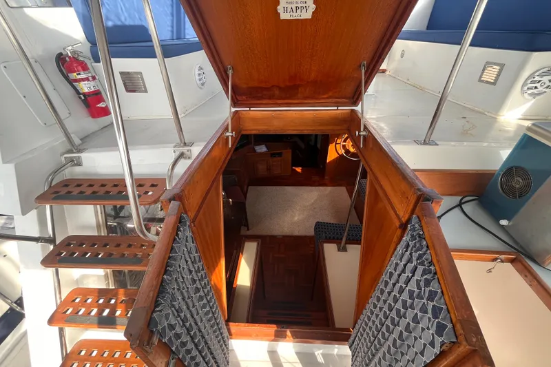 Slide: The Image of Interior view of 1986 Jefferson 42 SE Sundeck Motor Yacht, featuring wooden stairs and cozy cabin. - 15