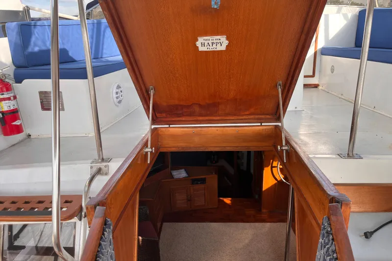 Slide: The Image of 1986 Jefferson 42 SE Sundeck Motor Yacht interior entrance with wooden hatch and blue seating. - 16