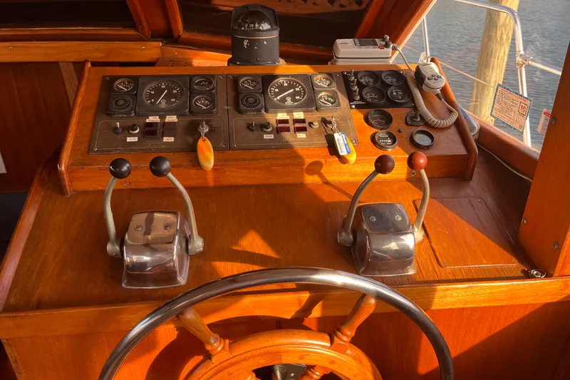 Slide: The Image of Control panel of a 1986 Jefferson 42 SE Sundeck Motor Yacht with steering wheel and throttle levers. - 22
