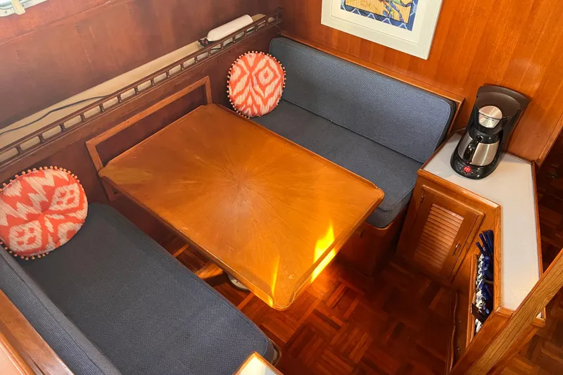 Slide: The Image of Cozy dining area in 1986 Jefferson 42 SE Sundeck Motor Yacht with wooden table and cushions. - 28