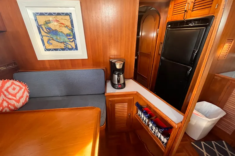 Slide: The Image of 1986 Jefferson 42 SE Sundeck Motor Yacht interior with cozy seating and kitchenette. - 29