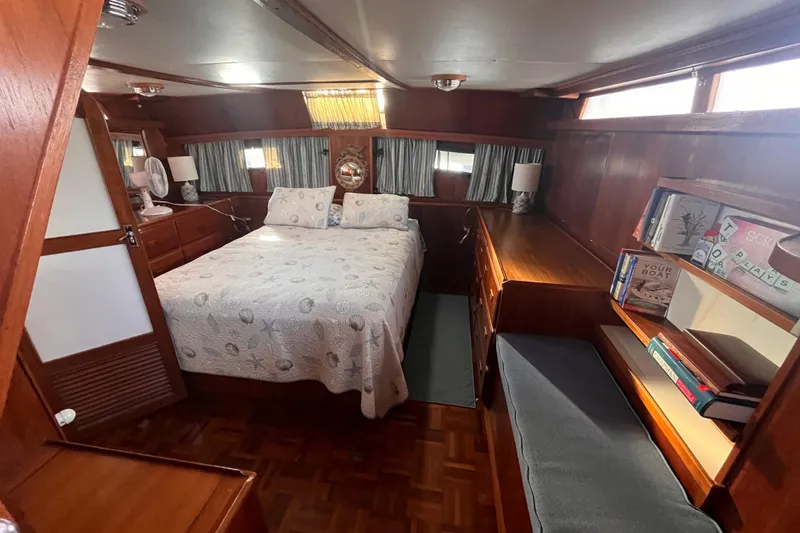 Slide: The Image of 1986 Jefferson 42 SE Sundeck Motor Yacht cabin with bed, wooden interior, and bookshelves. - 43