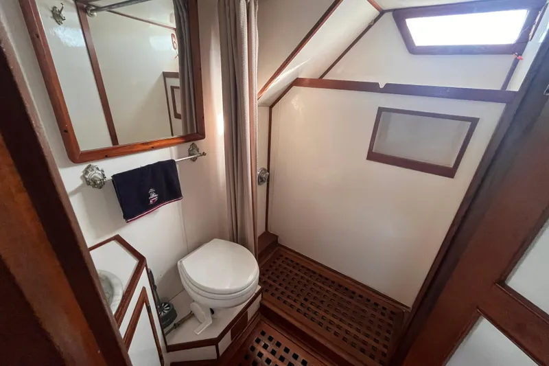 Slide: The Image of Bathroom interior of 1986 Jefferson 42 SE Sundeck Motor Yacht, featuring wood accents and nautical decor. - 45
