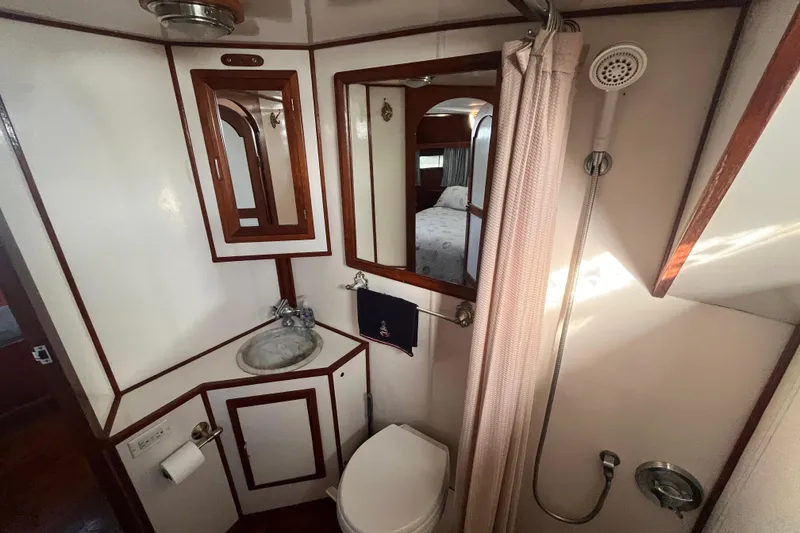 Slide: The Image of 1986 Jefferson 42 SE Sundeck Motor Yacht bathroom with shower, sink, and mirror. - 47