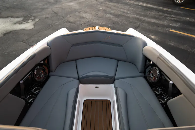 Slide: The Image of 2022 MasterCraft XStar boat interior with gray seating and wood accents. - 21