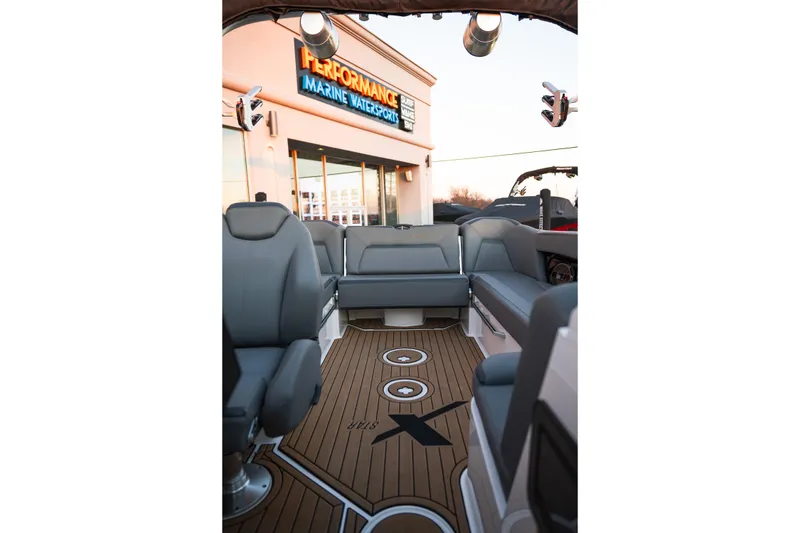 Slide: The Image of 2022 MasterCraft XStar boat interior with gray seating and teak flooring at a marine dealership. - 29