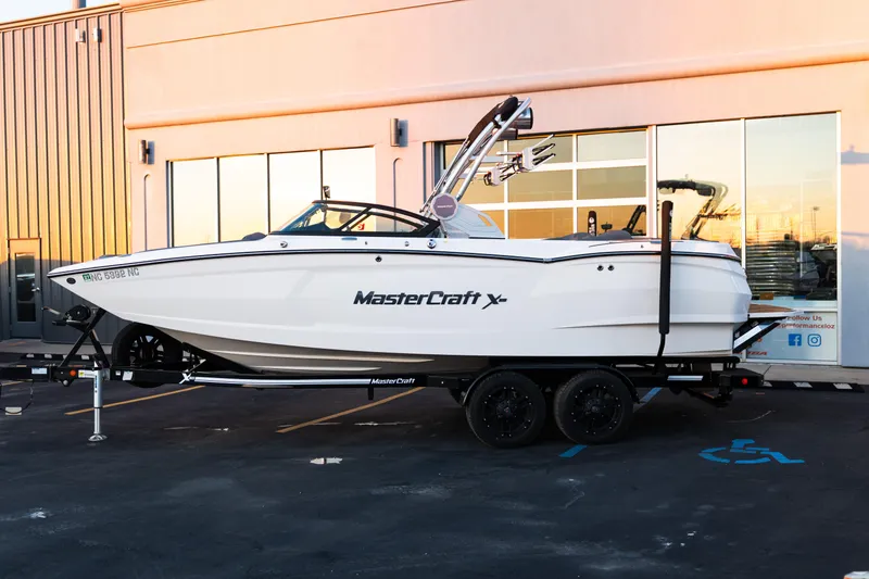 Slide: The Image of 2022 MasterCraft XStar boat on trailer outside a modern building. - 3