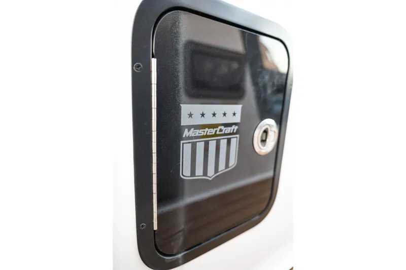 Slide: The Image of Close-up of 2022 MasterCraft XStar boat compartment with logo and lock. - 31