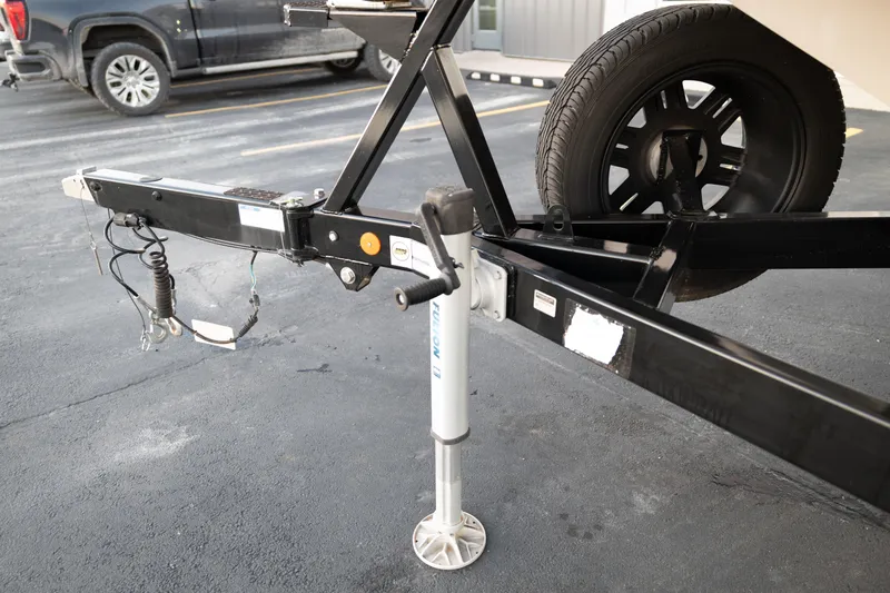 Slide: The Image of Trailer hitch and jack of a 2022 MasterCraft XStar boat on pavement. - 34