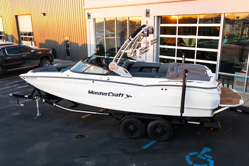 Slide: The Image of 2022 MasterCraft XStar boat on trailer outside dealership, showcasing sleek design and modern features. - 4