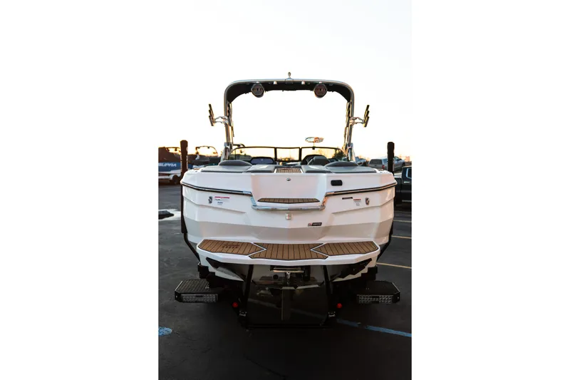 Slide: The Image of 2022 MasterCraft XStar boat rear view with teak swim platform in a parking lot. - 8