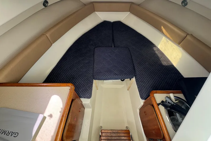 Slide: The Image of 2007 Pursuit OS 255 Offshore cabin interior with seating and storage. - 12