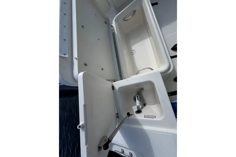 Slide: The Image of 2007 Pursuit OS 255 Offshore boat with open storage compartments and sink. - 15