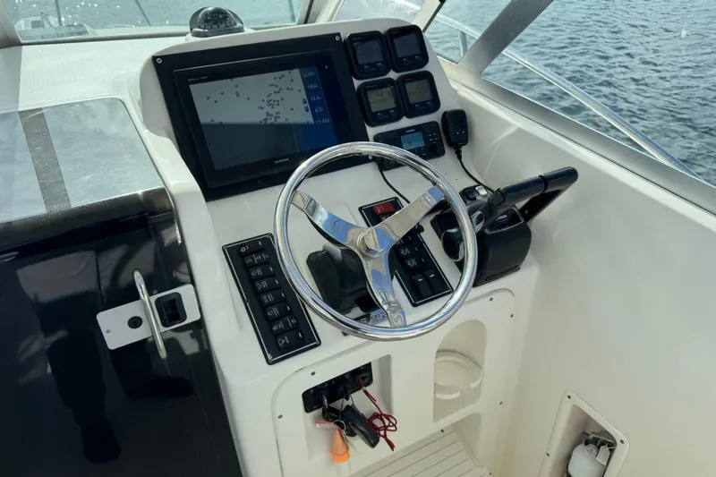 Slide: The Image of 2007 Pursuit OS 255 Offshore boat helm with steering wheel and navigation controls. - 5